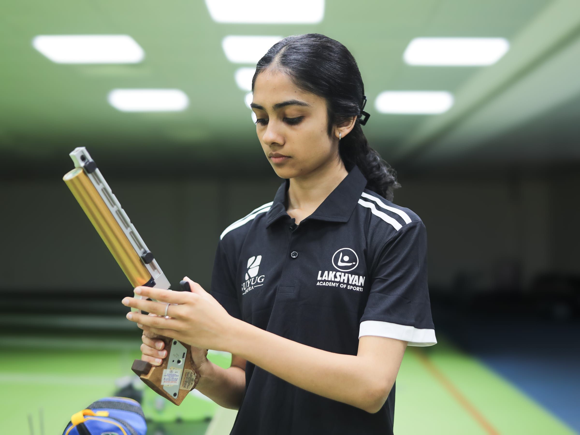 A young shooter preparing her pistol