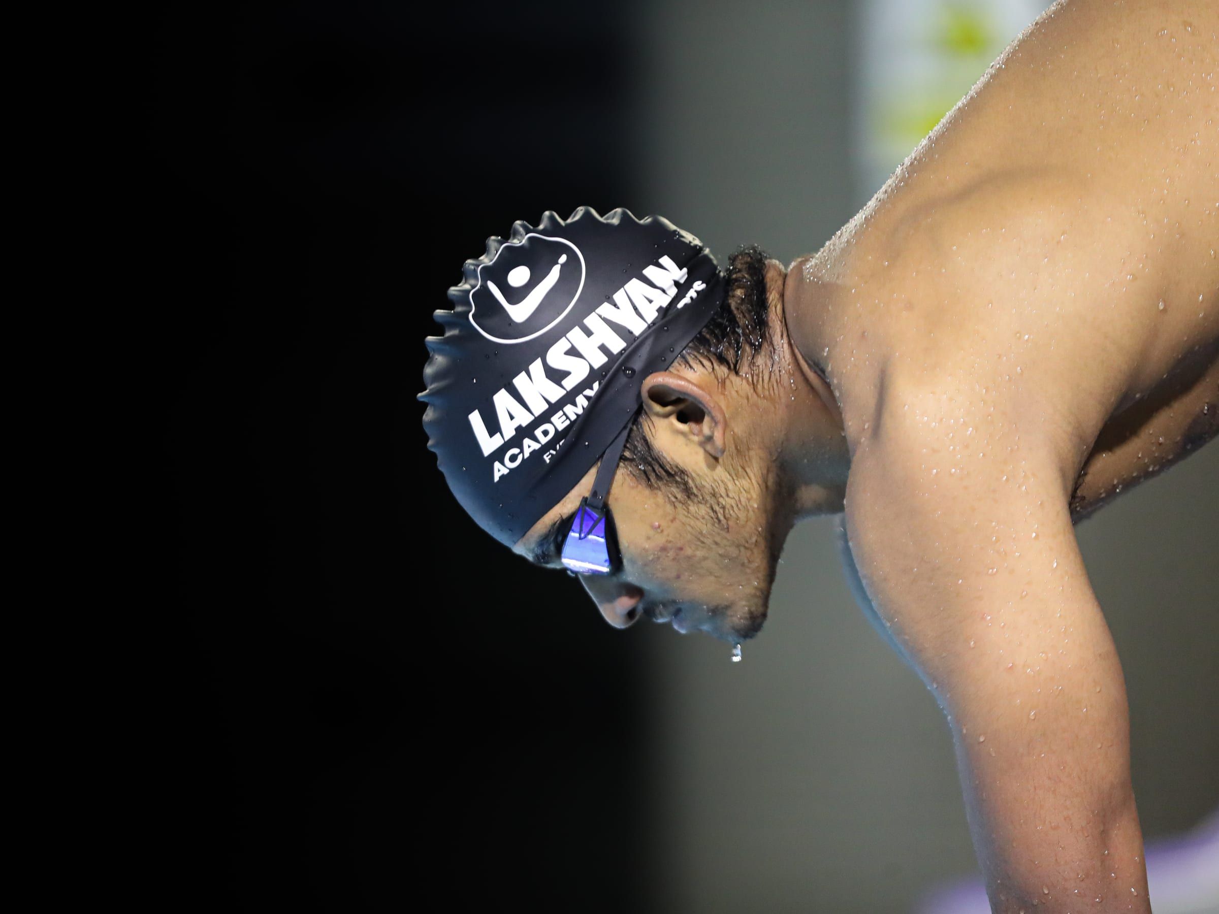 A swimmer in a Lakshyan cap and goggles poolside