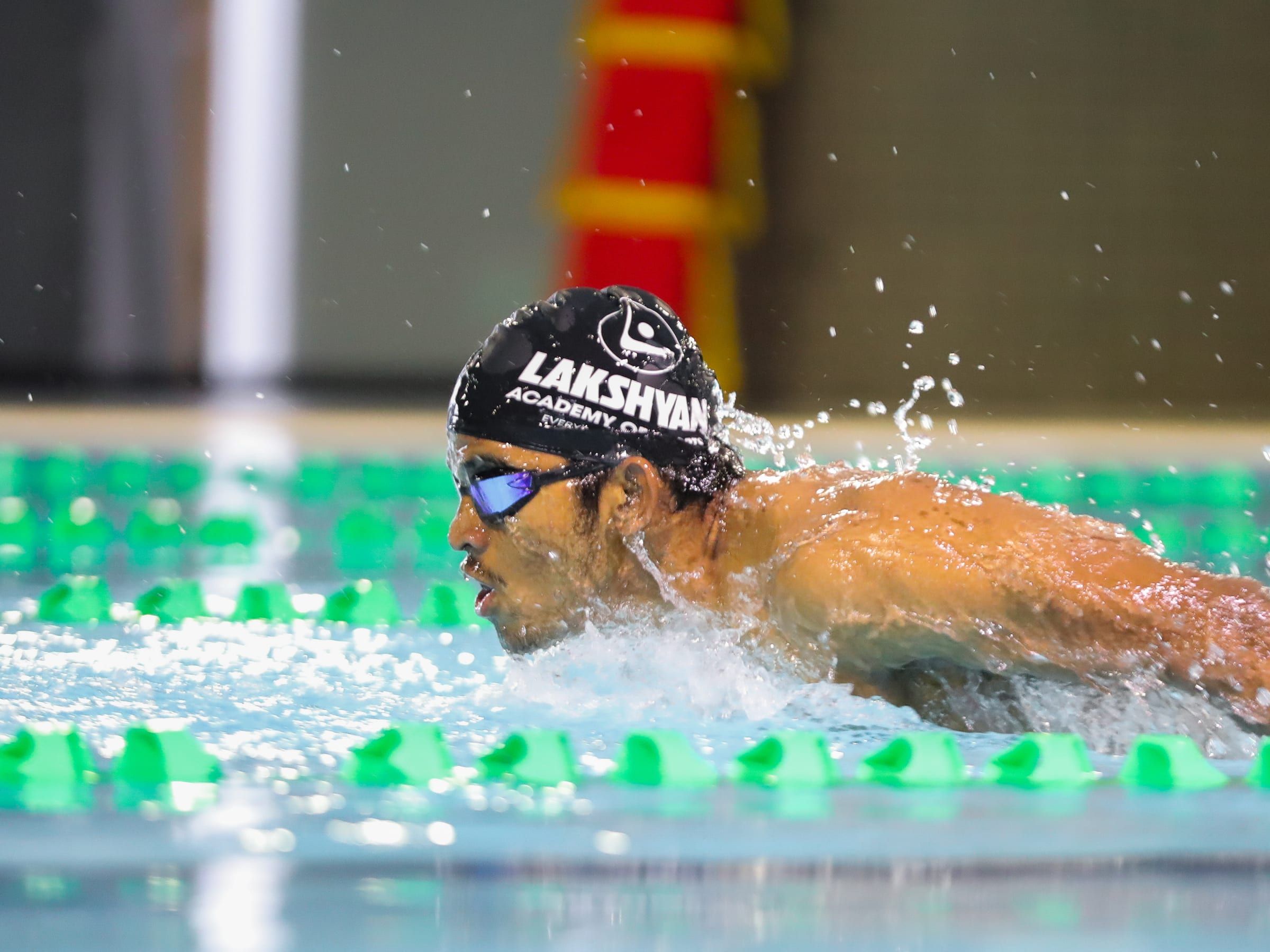 A swimmer mid-stroke during butterfly in the academy pool